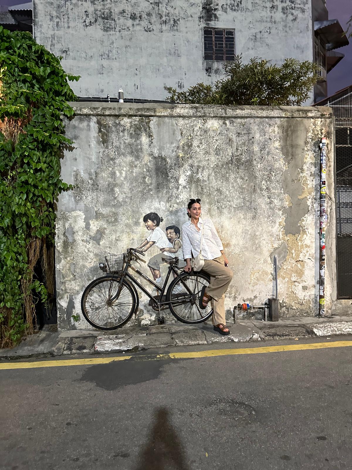 Lisa beside a bicycle mural